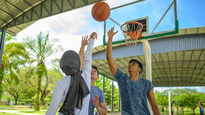 — title missing — Three people playing basketball.