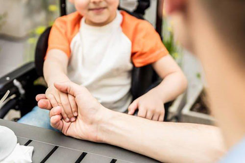 Un padres sosteniendo la mano de su hijo.