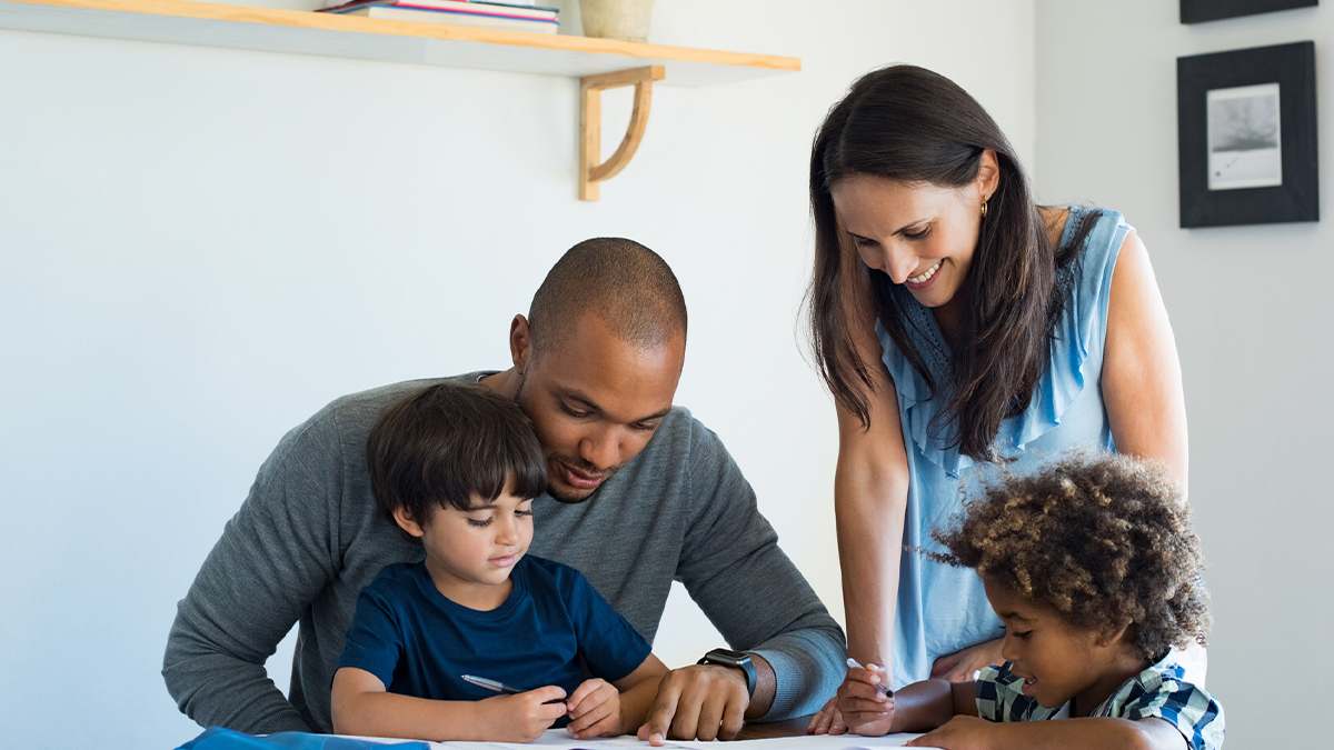 parents helping their two sons with homework Two parents helping their sons with homework