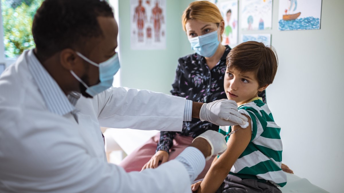 Boy Vaccine un médico que le administra la vacuna contra el VPH a un niño mientras su madre mira