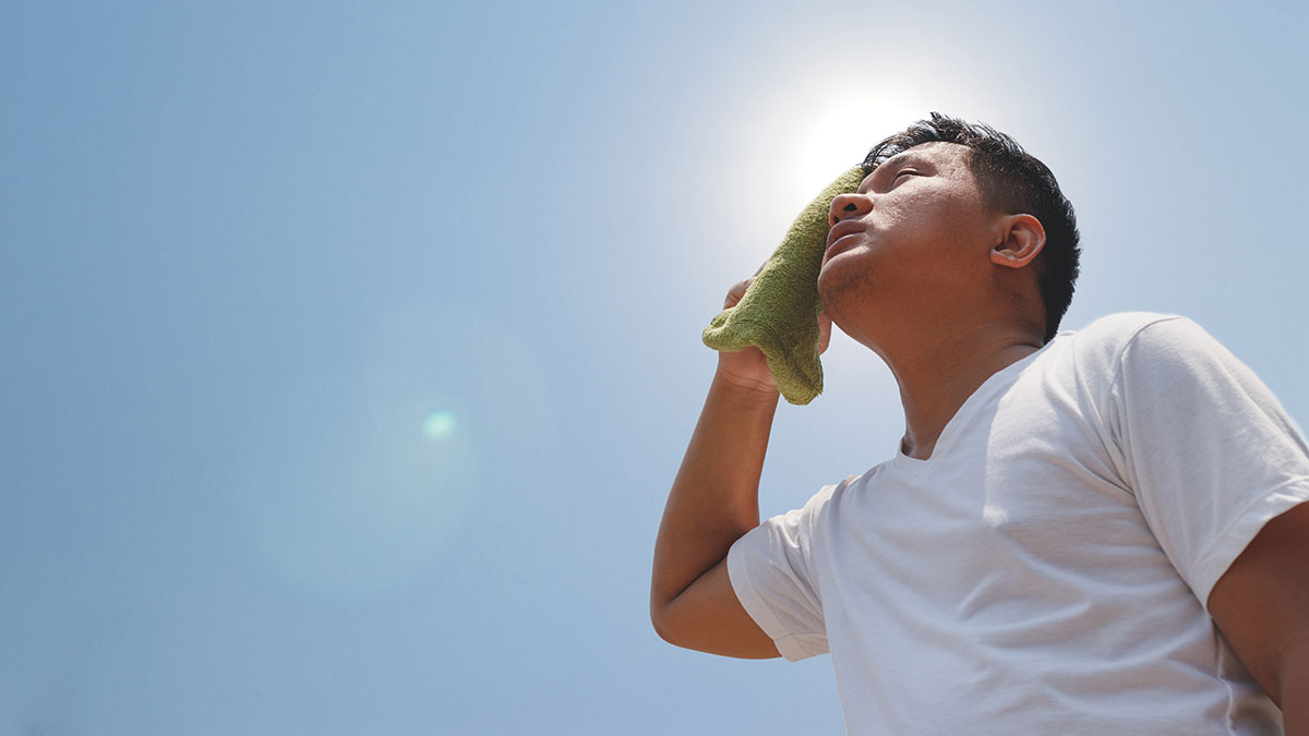 Heat Young man hot in sun and wiping face with towel