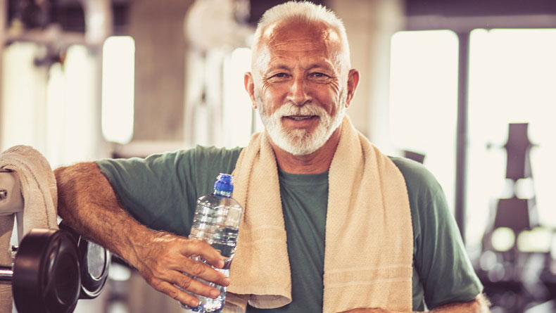 Refreshment Older man enjoying a bottle of water at the gym