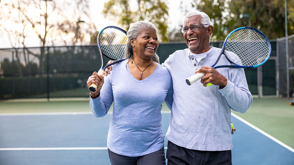 Couple exercising couple carrying tennis rackets