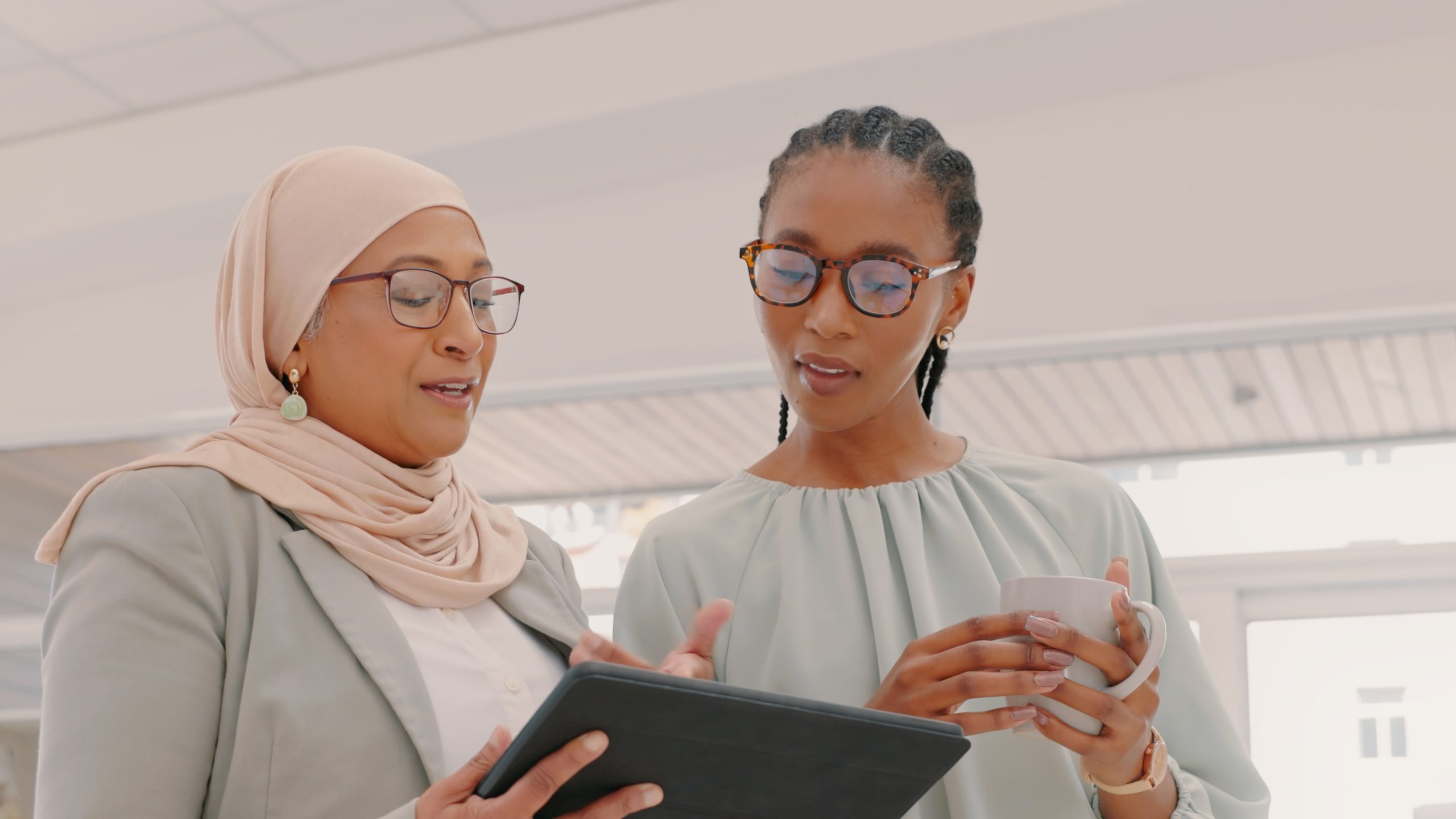 — title missing — Two women looking at tablet.