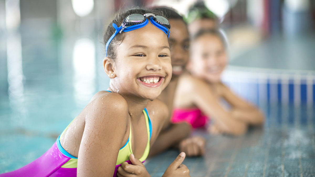 Young girl in swim lesson Young girl in swim lesson on pool edge