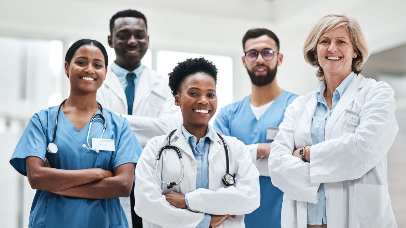Diverse group of doctors smiling with arms crossed