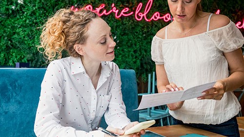 — title missing — Two women observing a menu.