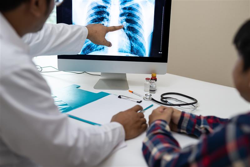 A physician reviews a chest X-ray A physician reviews a chest X-ray.