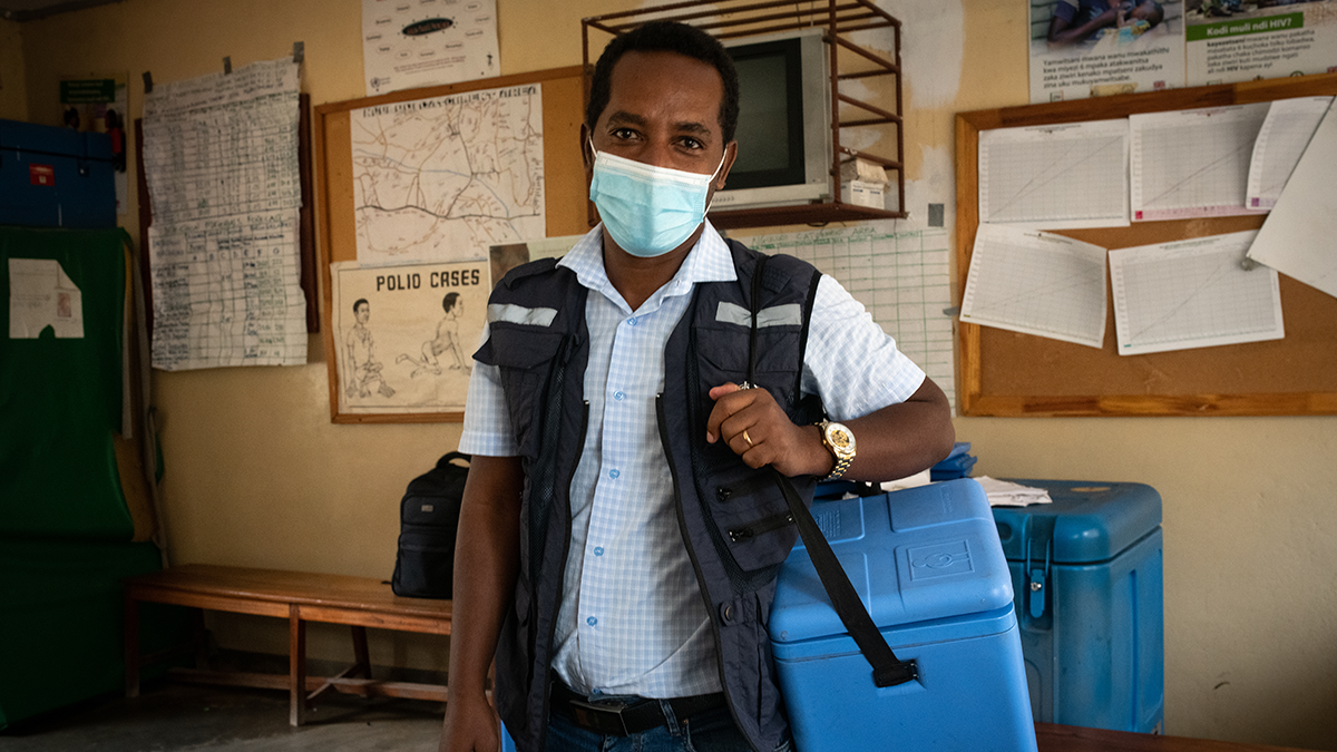 Health worker with a cooler delivering vaccines Health worker with a cooler delivering vaccines