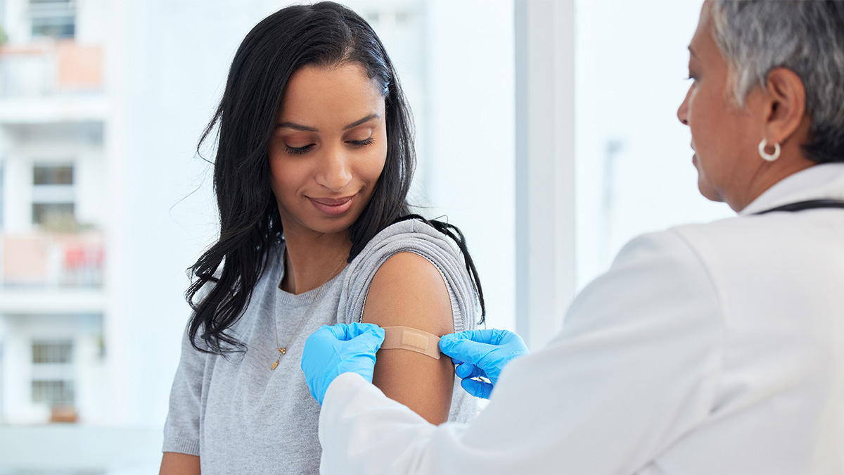 Hepatitis A Vaccination Thumbnail A doctor placing a bandage over the vaccination site on a patient's arm