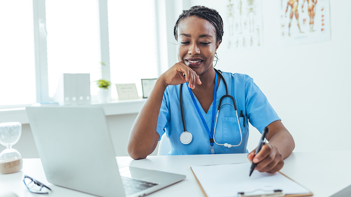 Healthcare professional checking their laptop for hepatitis b screening and testing information