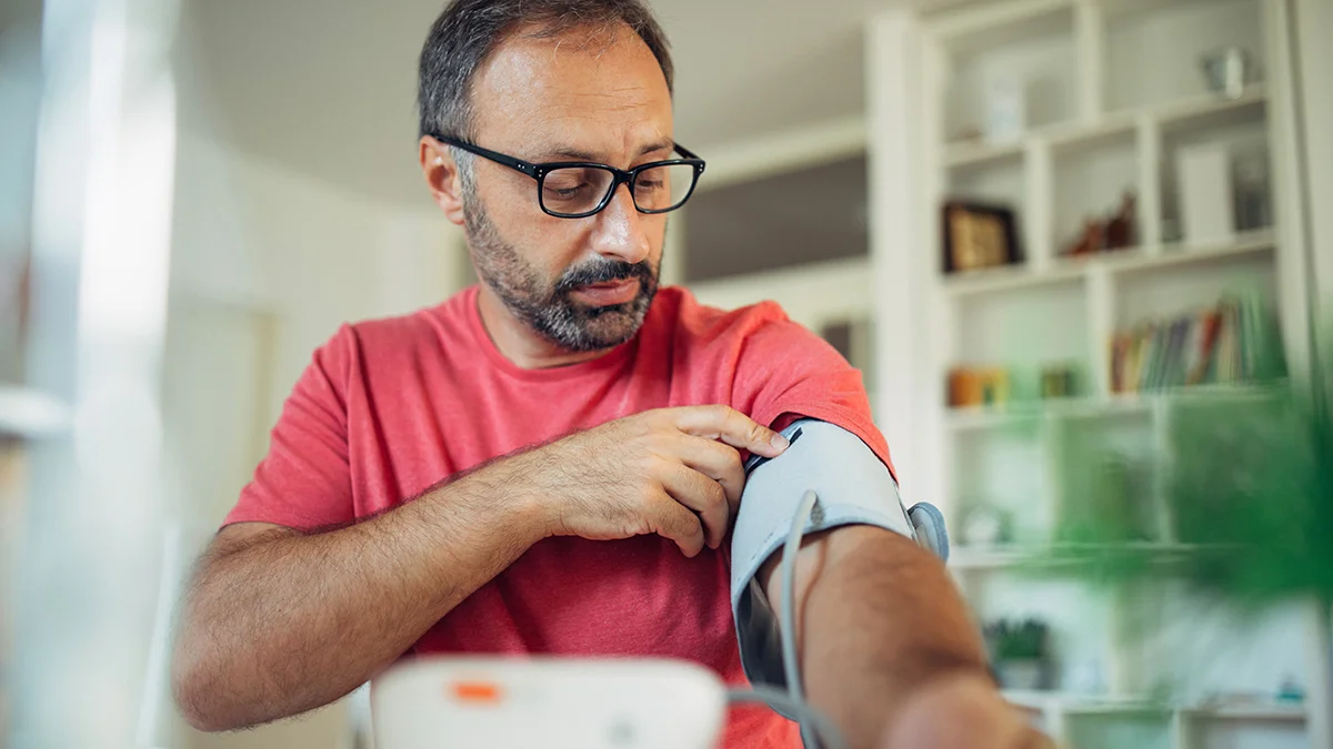 prevent-manage-bp Man checking blood pressure at home.