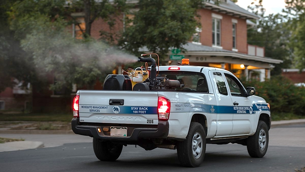 A truck sprays an adulticide in a city