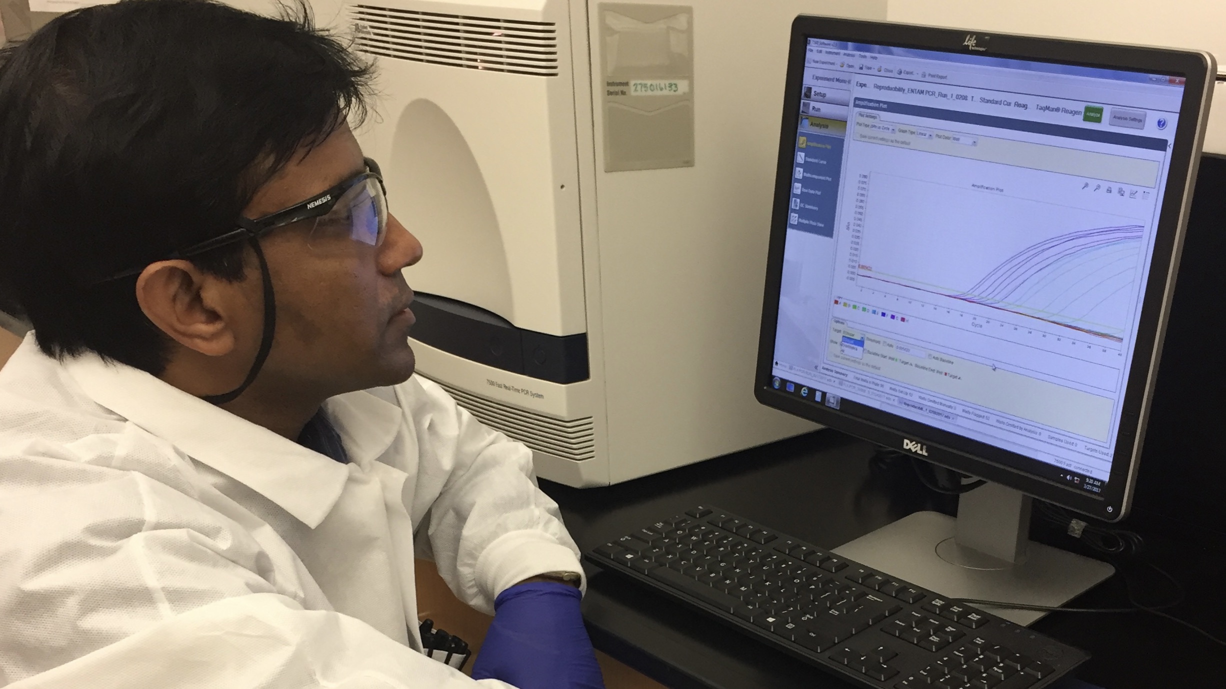CDC scientist Shantanu Roy sits in front of computer and runs a test on a suspected case of Naegleria fowleri