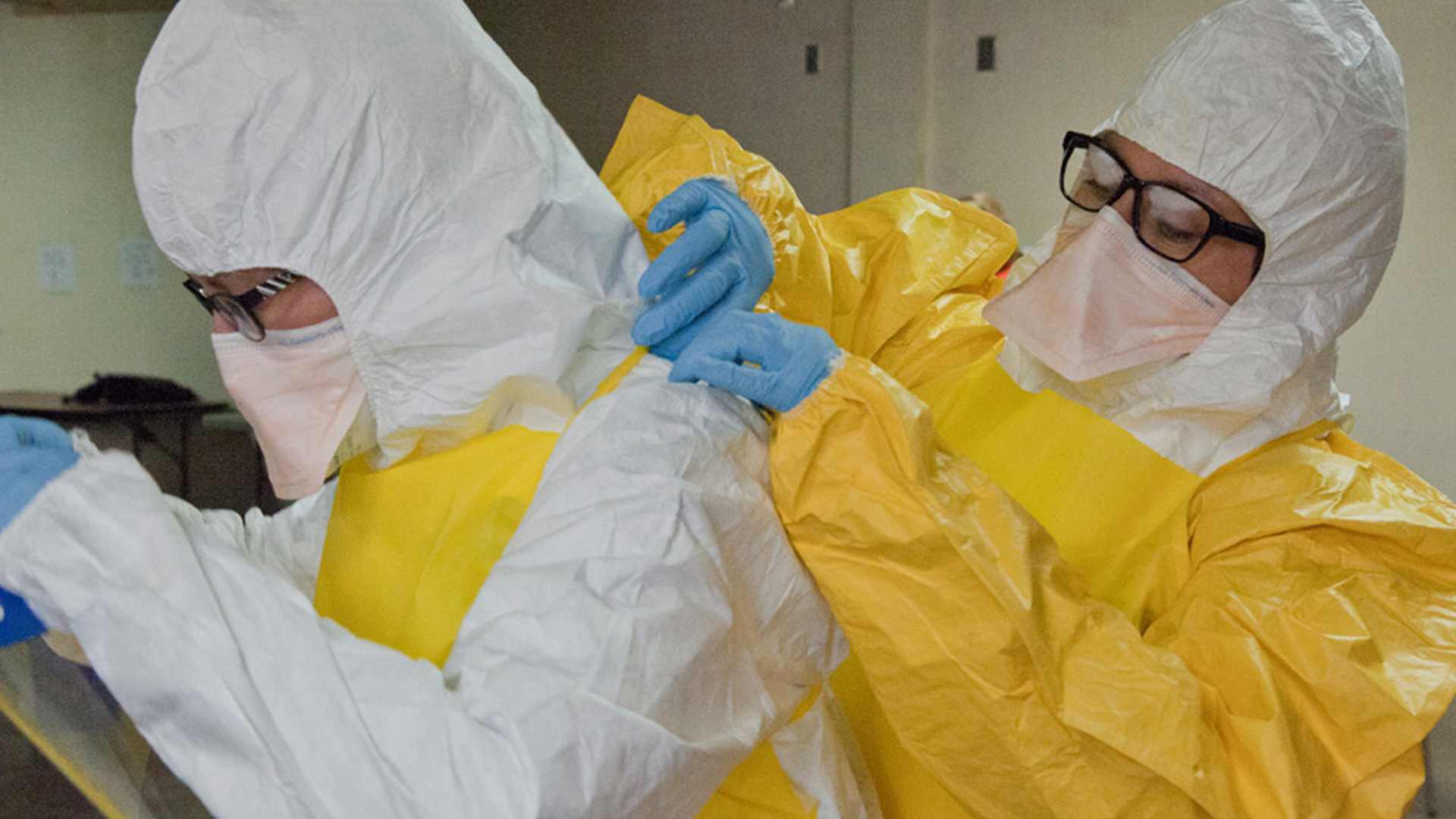 — title missing — Employees putting on personal protective equipment.