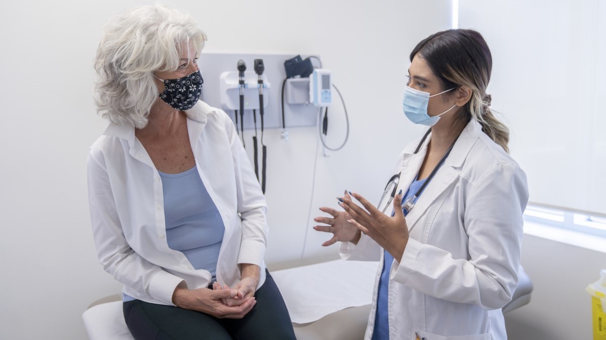 Doctor chart Foto de una mujer hablando con su médico