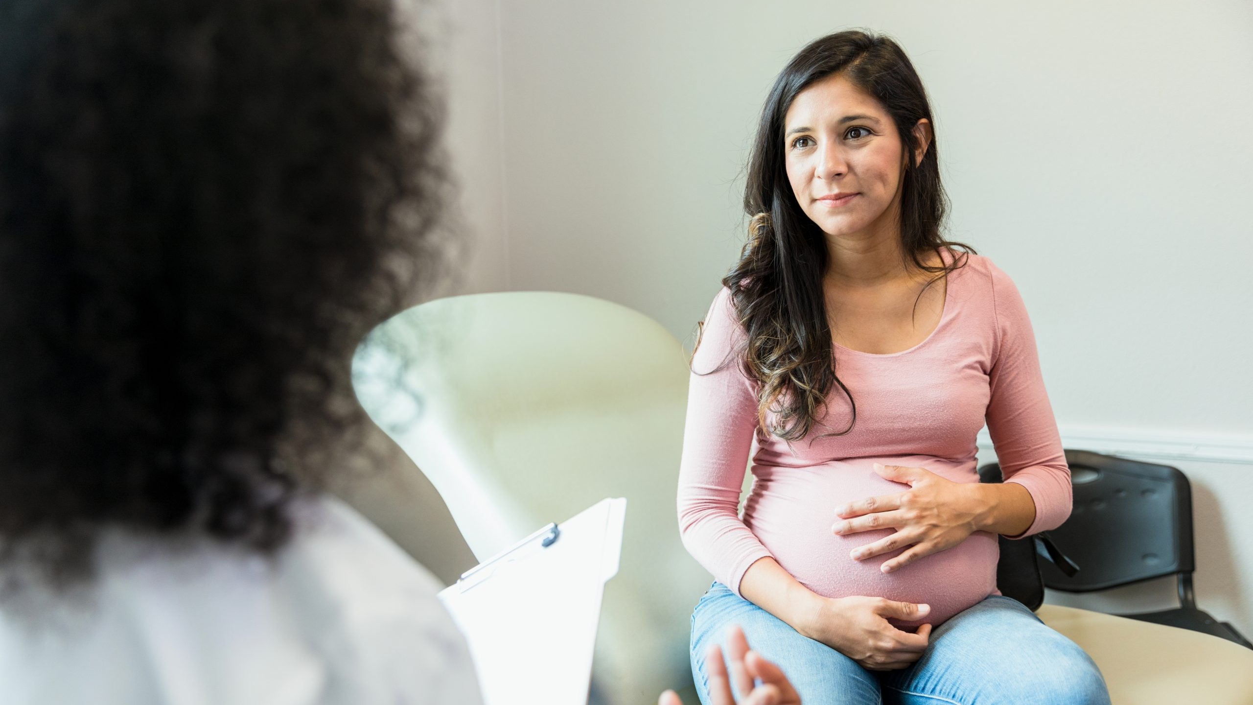 Pregnant woman speaks with a healthcare professional.