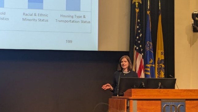A person presents a slideshow from behind a podium
