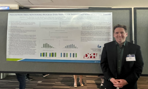 A person stands in front of a conference poster