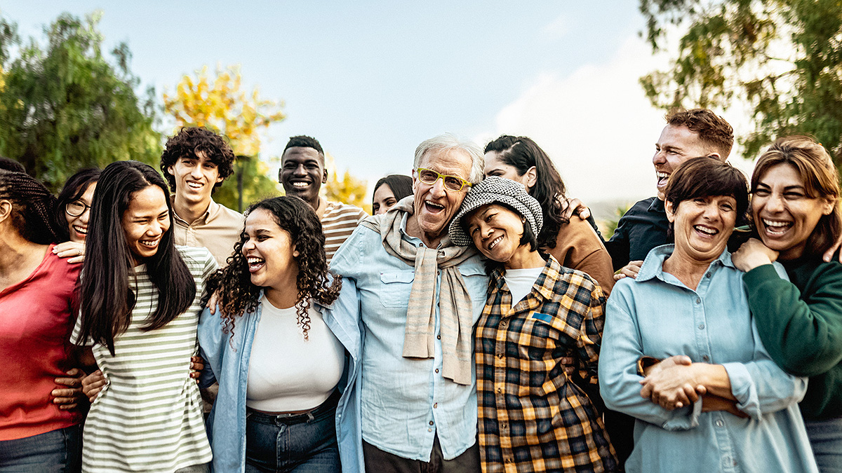 Multigenerational group outdoors Multigenerational, diverse group of adults embracing each other in a park.