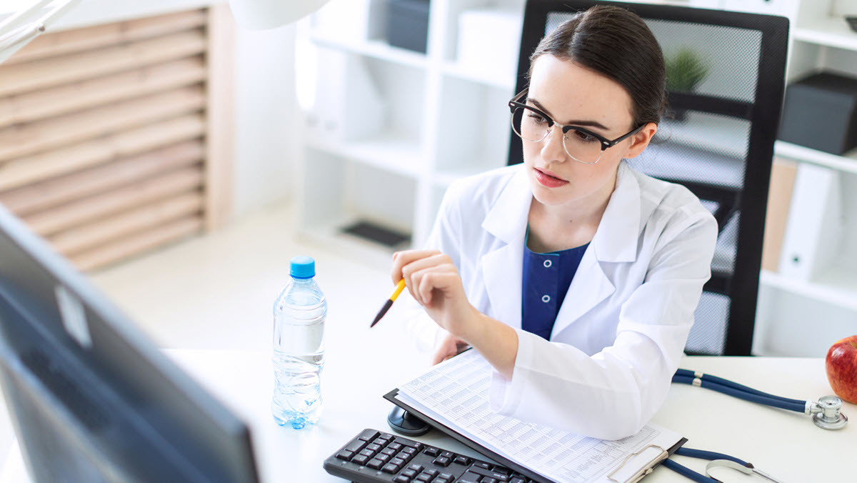 Health care provider seated at computer Healthcare provider looking at computer monitor