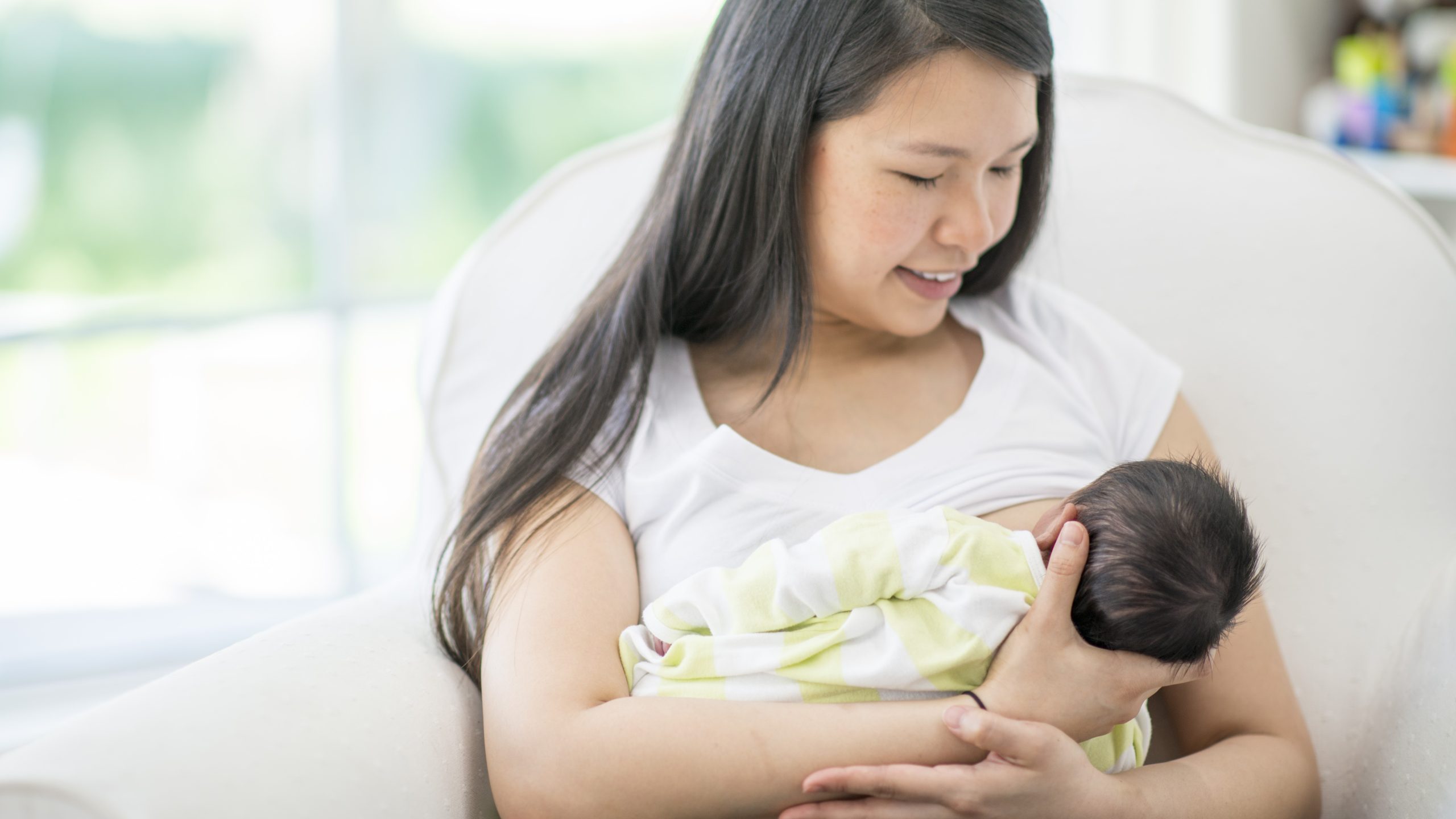 Woman breastfeeding in a chair.