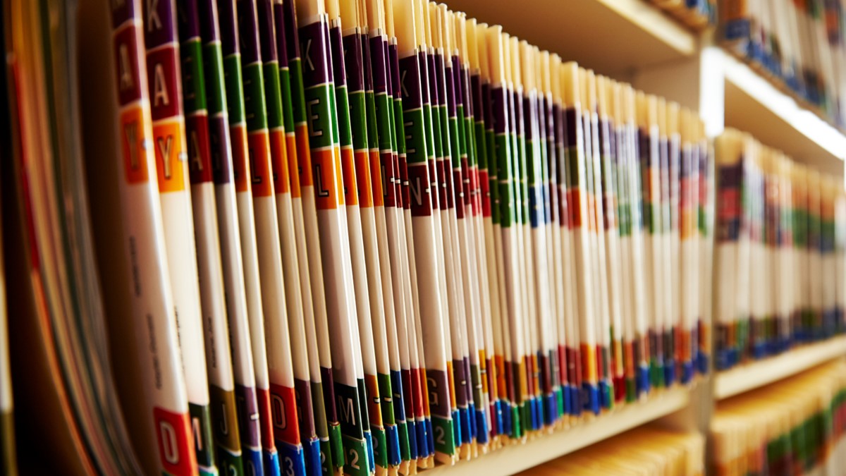 Three shelves are filled with bound reports.